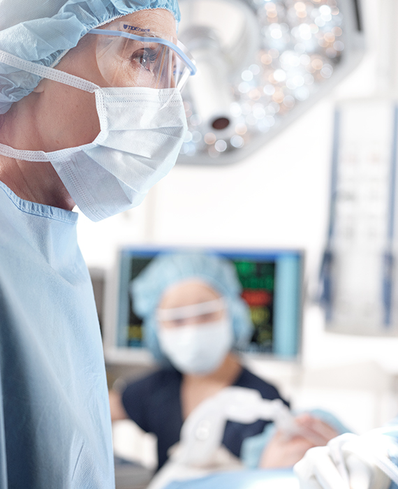 A surgical team operates on a patient with a TL 5000 series surgical light in the background