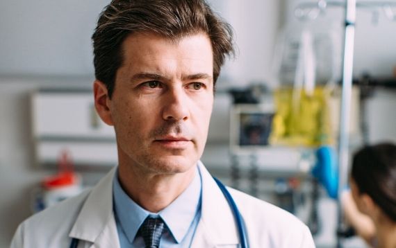 A close up of a doctor's face in a hospital room