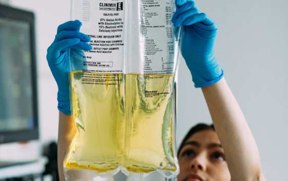 A nurse hangs a bag of Clinimix E for a patient who is receiving parenteral nutrition (PN)