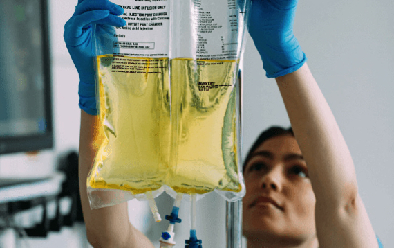 A nurse hangs a bag of Clinimix E for a patient who is receiving parenteral nutrition (PN)