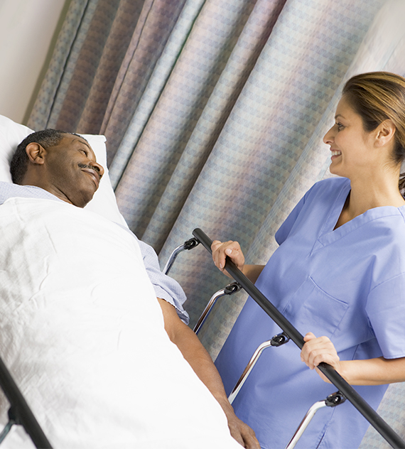 a smiling nurse cares for a patient in a post-op setting
