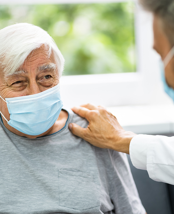 a clinician smiles while caring for an elderly patient