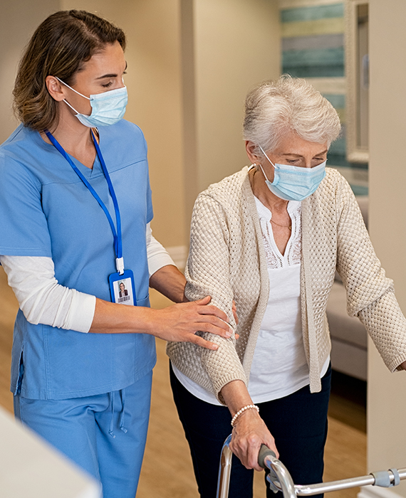 a nurse smiles while caring for an elderly patient