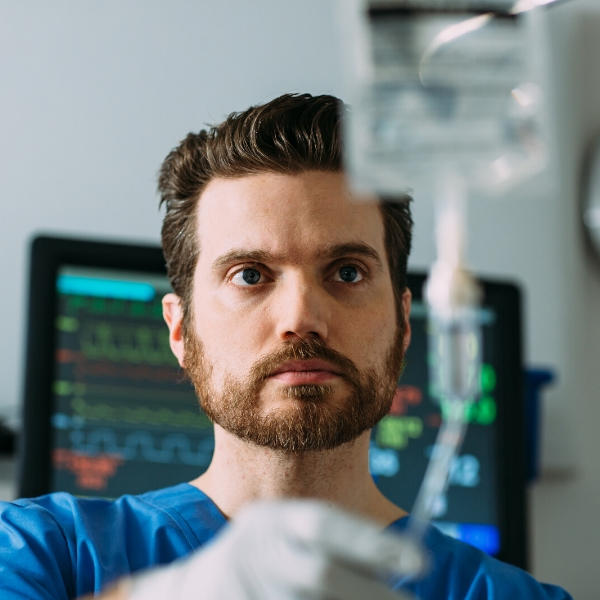 A nurse looks at a Baxter premixed medication on an IV pole