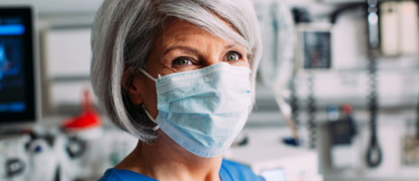 Female nurse with mask in hospital room